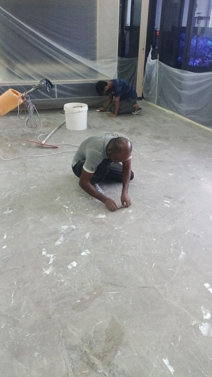 Technician filling small holes in marble before honing