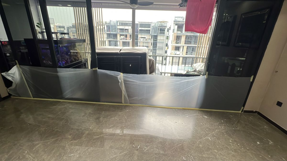 Plastic sheeting along a living room wall during marble polishing